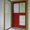 Lockable felt notice board in situ - Single door with wood frame - Cherry